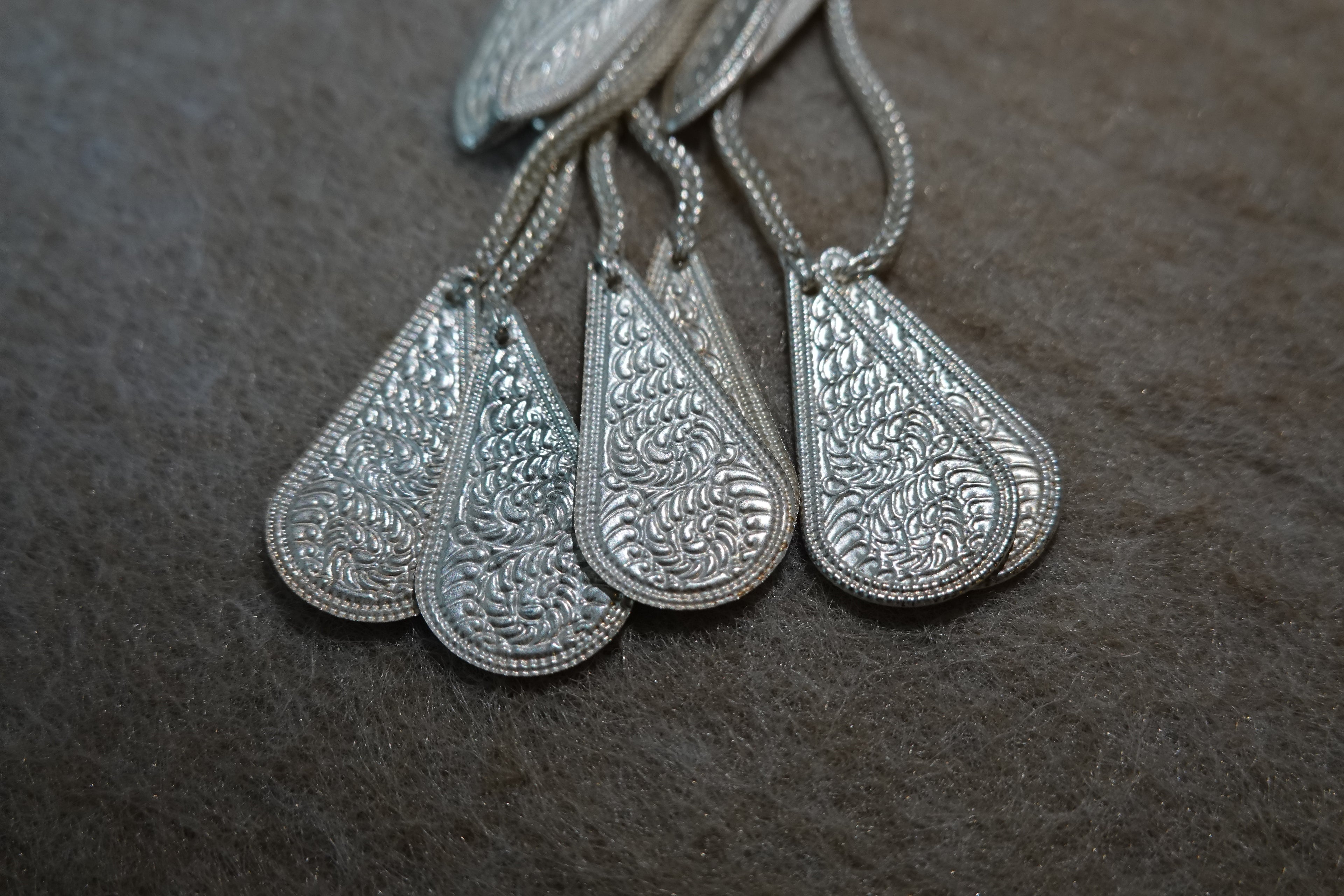 Yi-inspired silver tassel earring with engraved handmade details